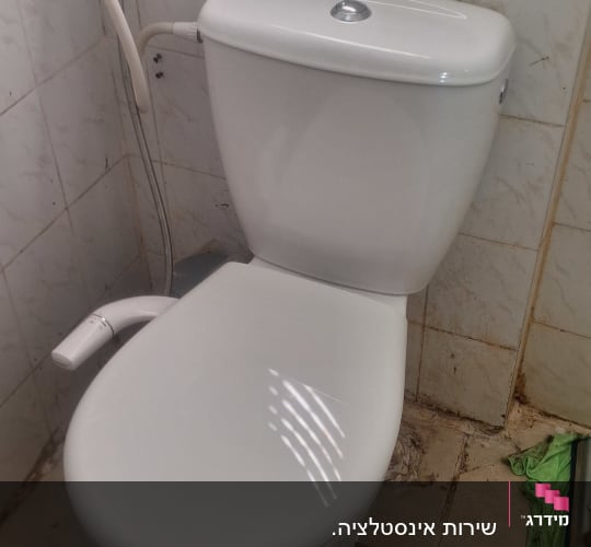 אסלה עם צינור מים בחדר אמבטיה
